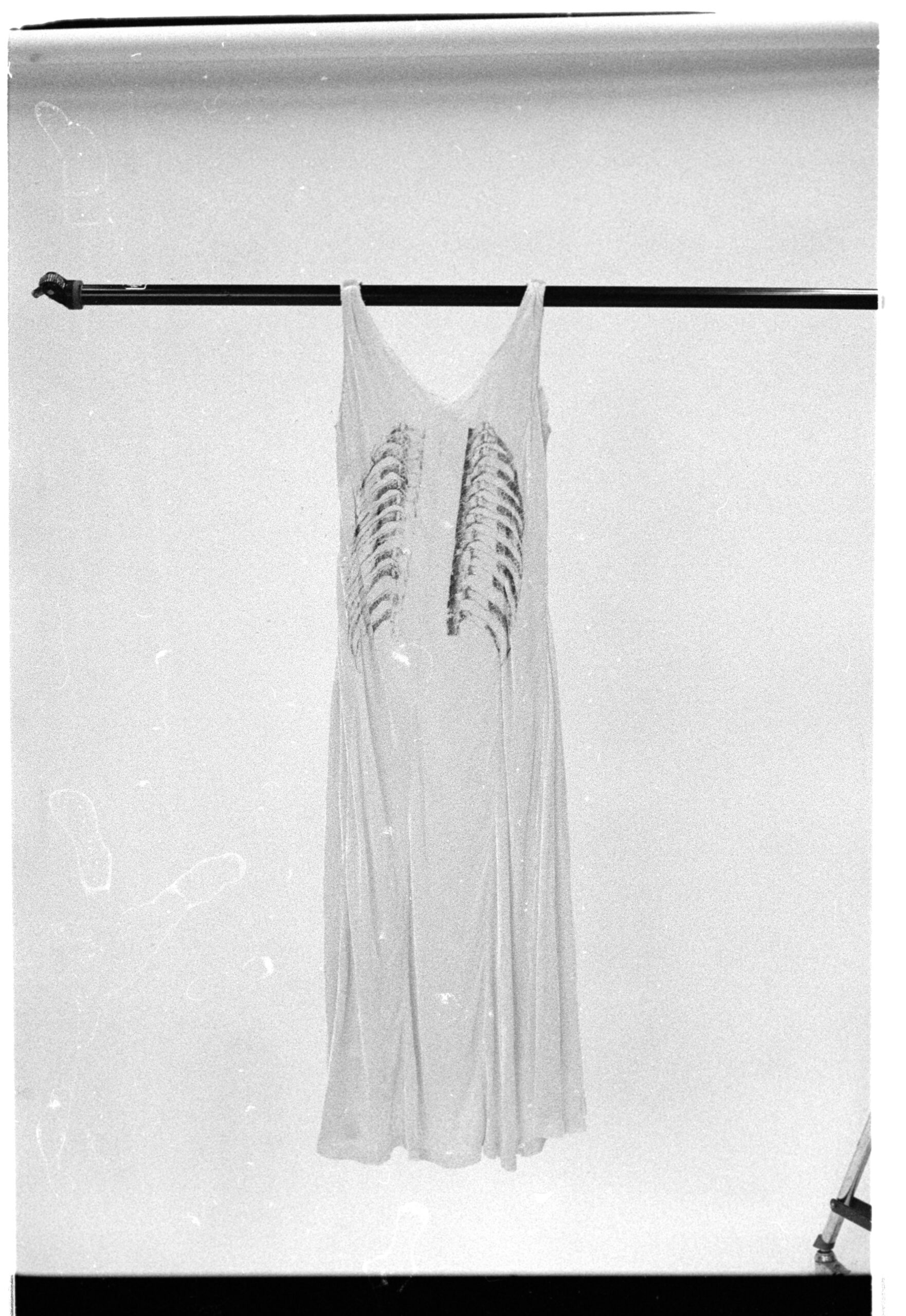 dress with rib cage printed on the back, hung on a rod