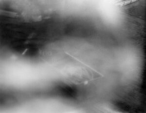 A black and white photograph of a construction site with a blur